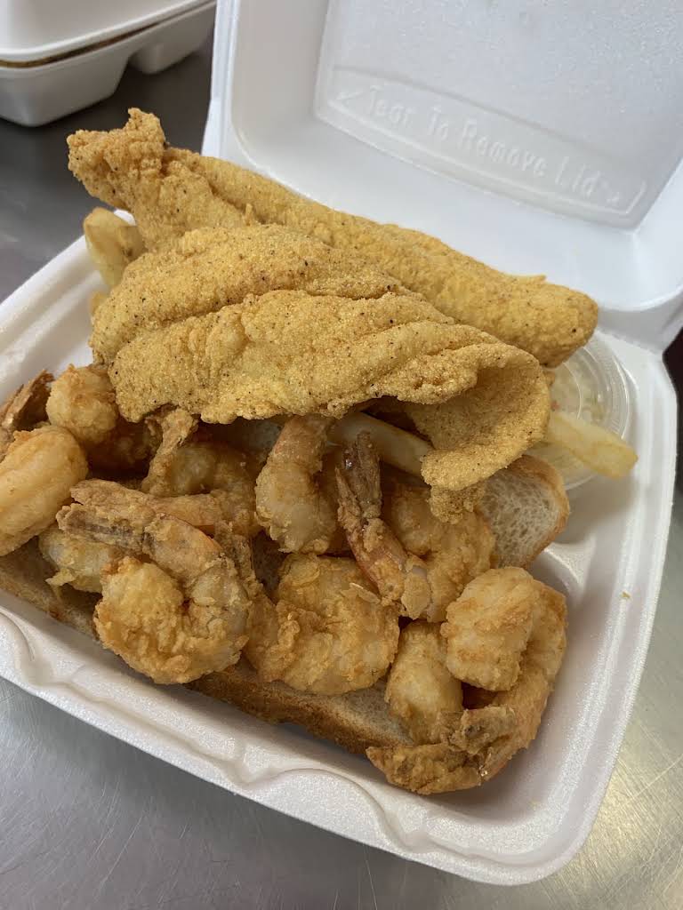 JJ Fish and Chicken’s fried fish and shrimp combo with fries in a takeout box