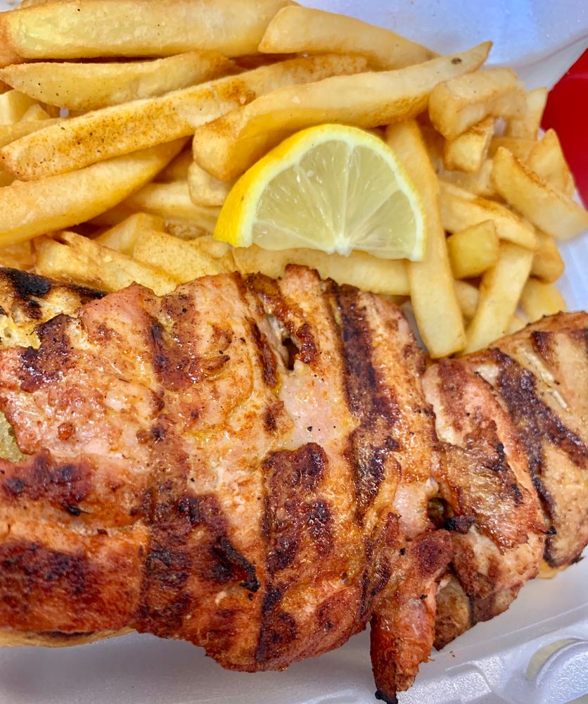 Seasoned grilled fish fillet with fries and lemon