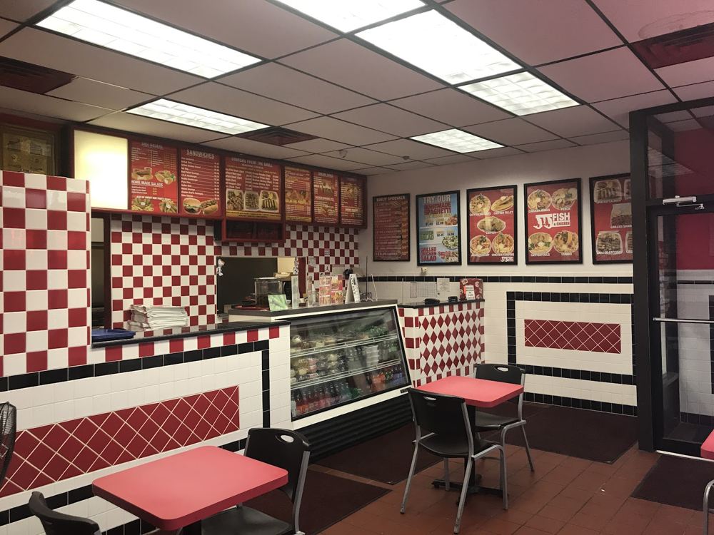 Inside JJ Fish and Chicken, with red seating and a red and white tiled counter